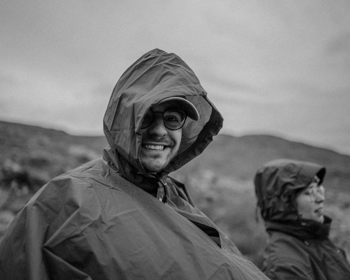 Diagram showing full-cover rain suit vs. raincoat: highlights sealed seams, integrated hood, and waterproof pants preventing water ingress at waist and legs