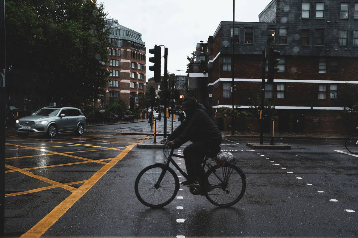 Cyclist wearing streamlined Cyclist-Friendly Rain Gear riding through urban Tampa downpour